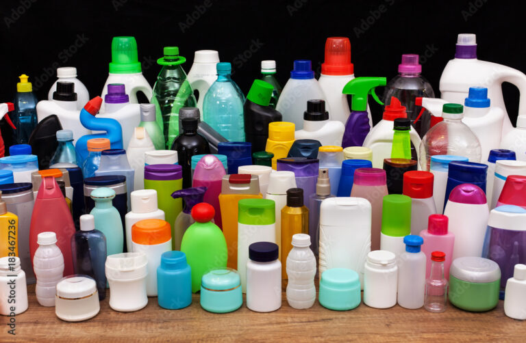 Assorted plastic bottles and containers on wooden surface.